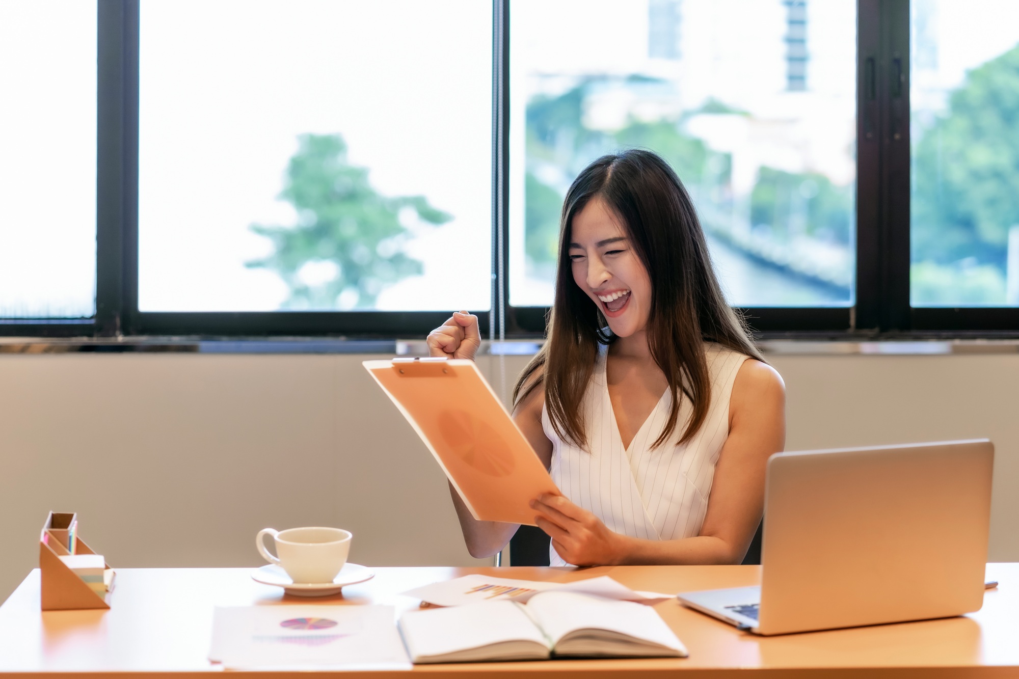 Asian businesswoman in casual suit are glad when looking the revenue in target